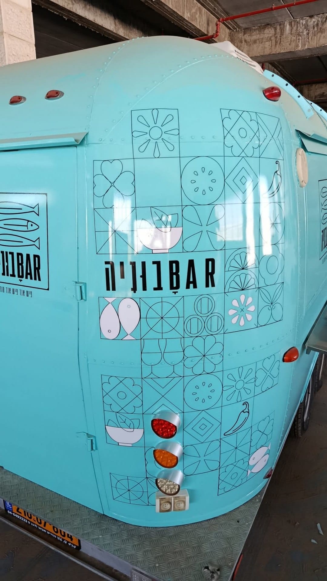 A turquoise graphic wrap on a street food van.